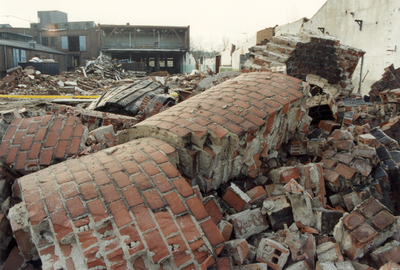 832738 Afbeelding van de restanten van de schoorsteen van de bandenfabriek U.B.O. (Kanaalweg 69) te Utrecht, tijdens de ...